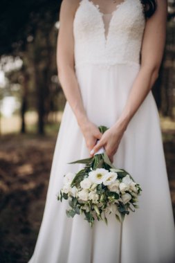 beautiful young bride with bouquet of flowers in brides hands