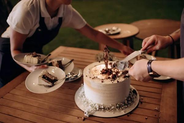 waiters carry cut wedding cake on plates