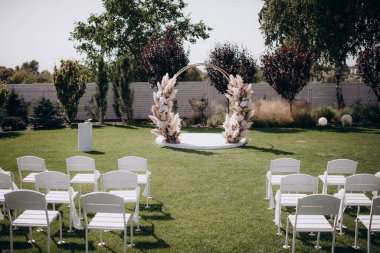 wedding ceremony arch with empty chairs and flowers. beautiful romantic decoration