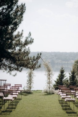 wedding ceremony arch with empty chairs and flowers. beautiful romantic decoration