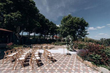wedding ceremony arch with empty chairs and flowers. beautiful romantic decoration