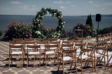 wedding ceremony arch with empty chairs and flowers. beautiful romantic decoration