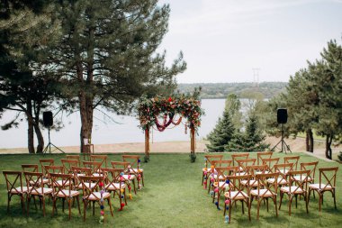 wedding ceremony arch with empty chairs and flowers. beautiful romantic decoration