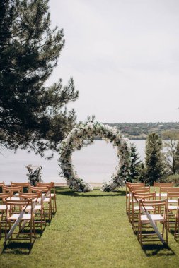 wedding ceremony arch with empty chairs and flowers. beautiful romantic decoration