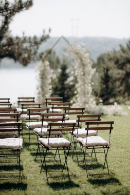 wedding ceremony arch with empty chairs and flowers. beautiful romantic decoration
