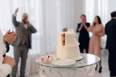 Şenlikli bir restoranın arka planında düğün pastası kes