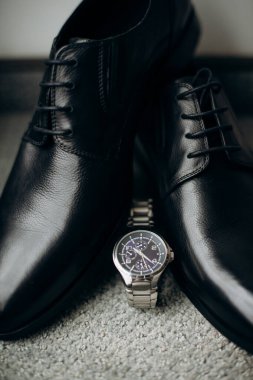 Bir saat ve halıda bir çift ayakkabı.