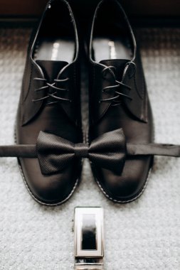 Bir çift ayakkabı ve halının üzerinde bir saat.