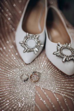 Gelinin pırıl pırıl nişan yüzüğü, şık topuklular. Gelinin düğün ayrıntıları ve aksesuarları..
