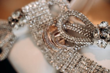 Gelinin pırıl pırıl nişan yüzüğü, şık topuklular. Gelinin düğün ayrıntıları ve aksesuarları..