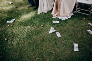 Pahalı giyimli kızların ayaklarına saçılmış sahte para. # Rüzgara para saçmak #