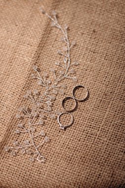 Nişan yüzüğüyle birlikte yakın plan gri bir tekstil yüzeyinde duruyor.