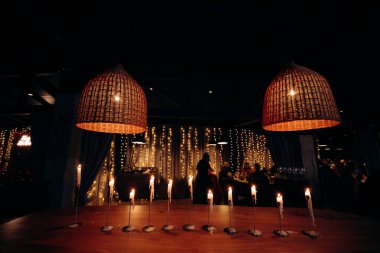 Karanlık kilisede birkaç uzun mum yakıldı. Ziyafet, restoran. Masa ayarı. Karanlık bir odada bir sürü uzun mum, alevler içinde beyaz ve uzun ayakta duran mumlar.