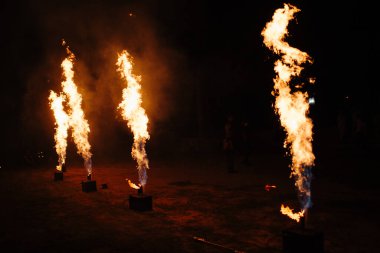 İnsanlar ellerinde dönen bir çarkla tutkulu bir dans ederler. Kabile dansçısı. Ateş gösterisi. Dolunayda sahilde salıncak etrafında ateş yakmak. Ateş geceleri birçok kıvılcım saçar.