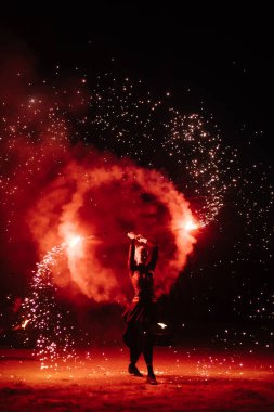 İnsanlar ellerinde dönen bir çarkla tutkulu bir dans ederler. Kabile dansçısı. Ateş gösterisi. Dolunayda sahilde salıncak etrafında ateş yakmak. Ateş geceleri birçok kıvılcım saçar.