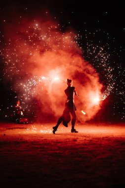 İnsanlar ellerinde dönen bir çarkla tutkulu bir dans ederler. Kabile dansçısı. Ateş gösterisi. Dolunayda sahilde salıncak etrafında ateş yakmak. Ateş geceleri birçok kıvılcım saçar.