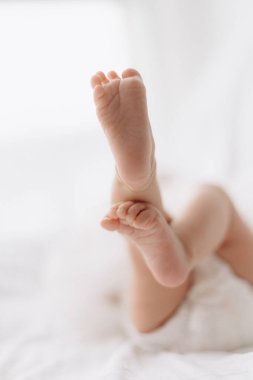 Beyaz bir yatakta küçük şirin ayaklar.