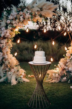 Çiçek desenli iki katlı beyaz düğün pastası