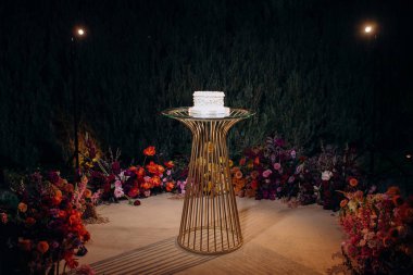 Altın geometrik bir stantta küçük beyaz desenli pasta