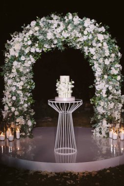 Beyaz çiçekli iki katlı düğün pastası.