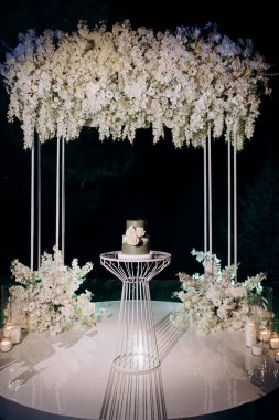 İki katlı koyu yeşil düğün pastası ve beyaz güller.