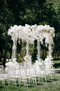 Beyaz narin sandalyeler, el değmemiş beyaz bir koridor ve bol bol beyaz çiçeklerle süslenmiş uzun bir kemer içeren bir huş ağacının koruluğunda yapılan büyüleyici bir düğün töreni.