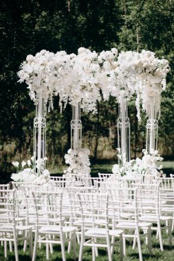Beyaz narin sandalyeler, el değmemiş beyaz bir koridor ve bol bol beyaz çiçeklerle süslenmiş uzun bir kemer içeren bir huş ağacının koruluğunda yapılan büyüleyici bir düğün töreni.