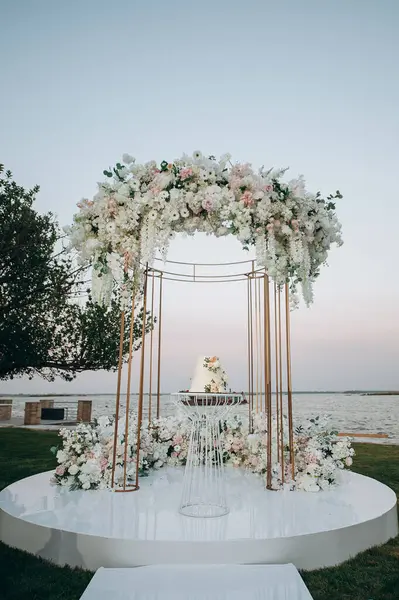 Şeftalili ve beyaz çiçekli üç katlı düğün pastası.