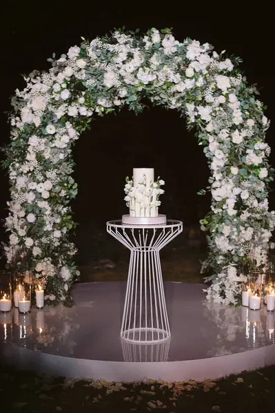 Beyaz çiçekli iki katlı düğün pastası.