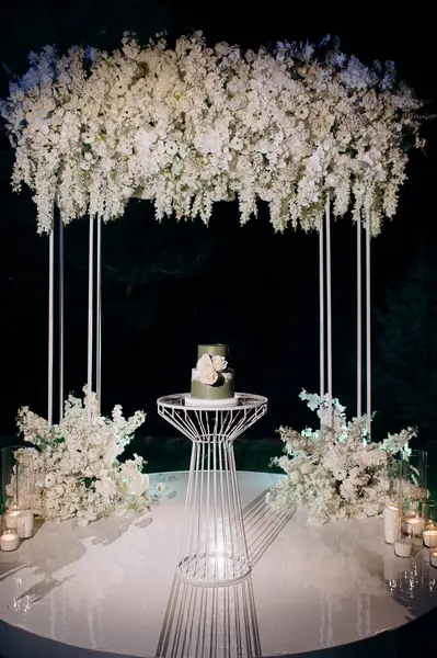 İki katlı koyu yeşil düğün pastası ve beyaz güller.