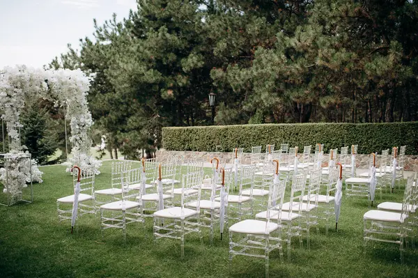 Beyaz narin sandalyeler, el değmemiş beyaz bir koridor ve bol miktarda beyaz çiçeklerle süslenmiş bir kemer içeren bir huş ağacının koruluğunda yapılan büyüleyici bir düğün töreni.