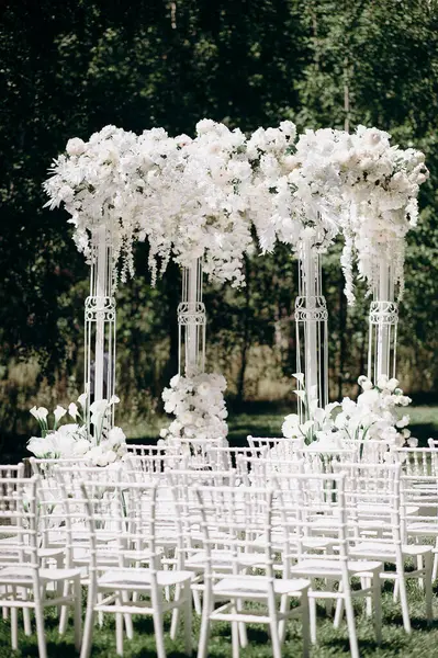 Beyaz narin sandalyeler, el değmemiş beyaz bir koridor ve bol bol beyaz çiçeklerle süslenmiş uzun bir kemer içeren bir huş ağacının koruluğunda yapılan büyüleyici bir düğün töreni.
