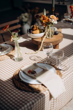 Çiçek aranjmanları ve mumlarla şenlik masası. Sıcak, zarif bir atmosfer.