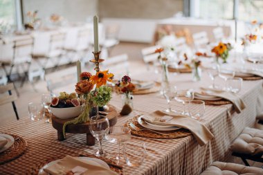 Çiçek aranjmanları ve mumlarla şenlik masası. Sıcak, zarif bir atmosfer.