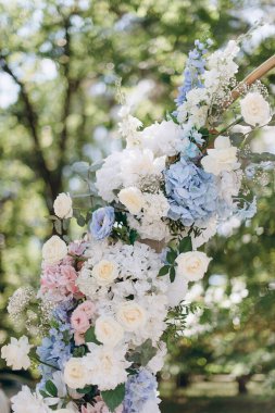 Bulanık yeşil arka planda pembe, beyaz ve mavi çiçeklerden oluşan yemyeşil bir çiçek düzeni.