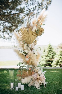 Açık havada pampalar ve güllerle zarif bir çiçek aranjmanı.