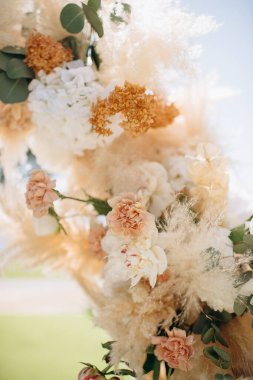 Açık havada pampalar ve güllerle zarif bir çiçek aranjmanı.