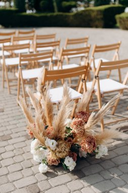 Açık havada otlar ve kasımpatılar ile zarif bir çiçek aranjmanı.