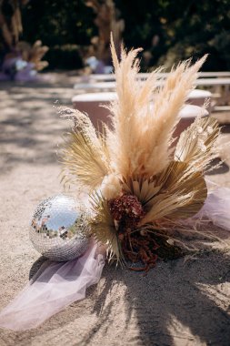 Kurumuş çiçekli disko topu ve taş bir yüzeyde mor tül.