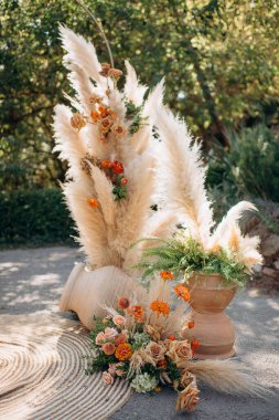 Pampa otları ve açık havada renkli çiçeklerle zengin bohem çiçek aranjmanları.