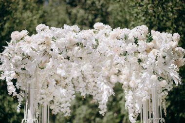 Beyaz salkımlarla kaplı lüks düğün kemeri ve bebek nefesi
