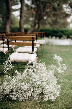 Bebek nefesi ve ahşap banklarla dolu taşra düğün koridoru.