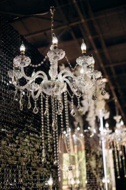 Alev şeklinde ampulleri olan zarif kristal avize.