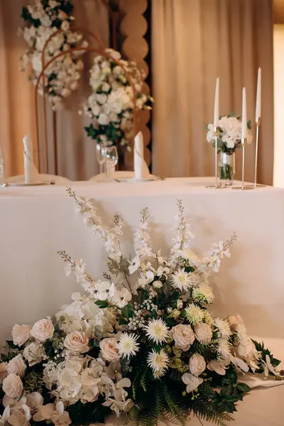 Beyaz çiçekli ve mumlu zarif bir düğün masası. Yumuşak, romantik atmosfer