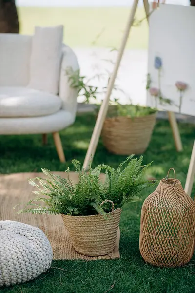 Dokuma sepetlerinde bitkiler ve örgü pouf örülü açık hava salonu dekoru. Doğal, bohem atmosfer