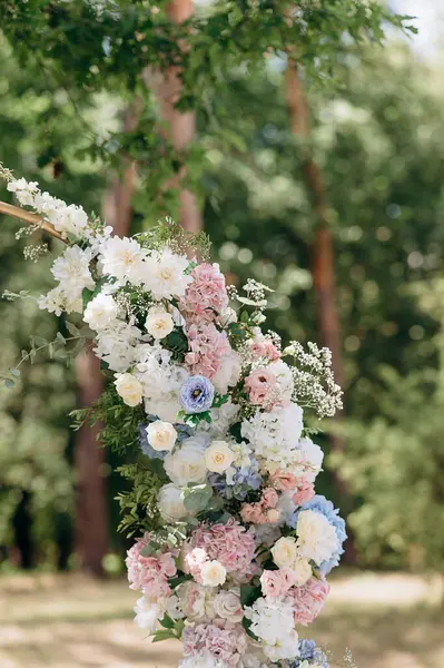 Bulanık yeşil arka planda pembe, beyaz ve mavi çiçeklerden oluşan yemyeşil bir çiçek düzeni.