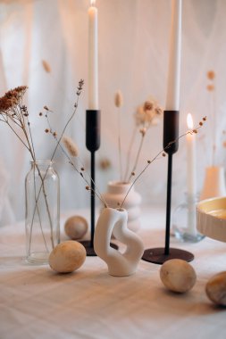 Mumlar, çiçekler ve yumurtalarla süslü Paskalya sofrası.