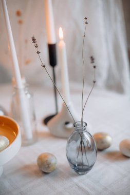 Minimalist paskalya dekoru lavantalı, dekoratif yumurtalı ve mum ışığında.