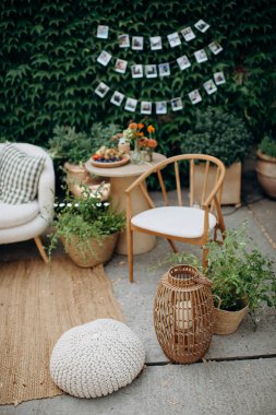 Masası, sandalyeleri ve bitkileri olan rahat bir açık hava salonu.