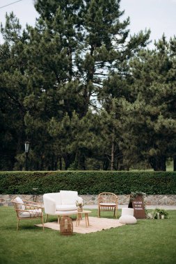 Yeşil çimenlikte hoş geldin tabelası olan zarif bir düğün salonu.